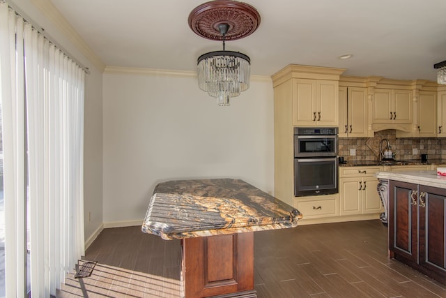 kitchen with double oven, cream cabinets, decorative backsplash, dark wood-style floors, and crown molding