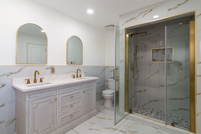 bathroom featuring marble finish floor, a marble finish shower, a sink, and toilet