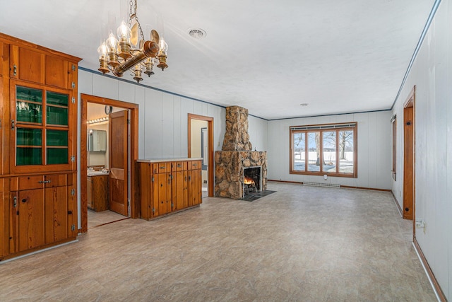 unfurnished living room with ornamental molding, an inviting chandelier, and a fireplace