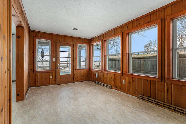 unfurnished sunroom featuring a baseboard heating unit