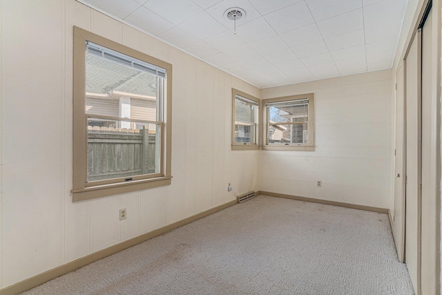 unfurnished room featuring plenty of natural light and light carpet