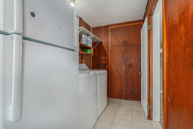 clothes washing area featuring washing machine and clothes dryer and light tile patterned flooring