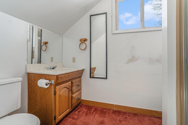 bathroom with vanity, vaulted ceiling, and toilet