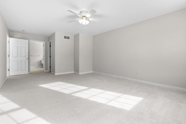 unfurnished bedroom with ceiling fan, ensuite bath, and light carpet