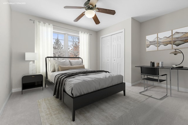 bedroom with ceiling fan, light colored carpet, and a closet