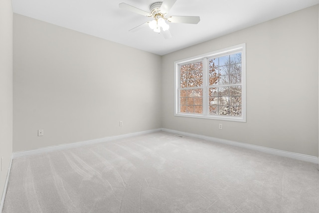 carpeted spare room featuring ceiling fan