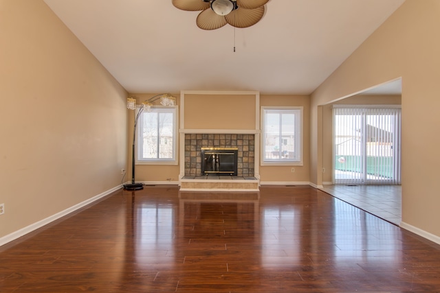 unfurnished living room with vaulted ceiling, dark wood finished floors, and a healthy amount of sunlight