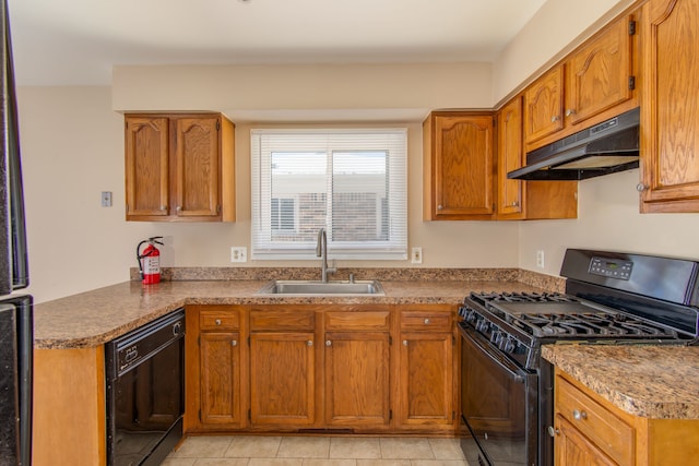 kitchen with black appliances, under cabinet range hood, brown cabinets, and a sink