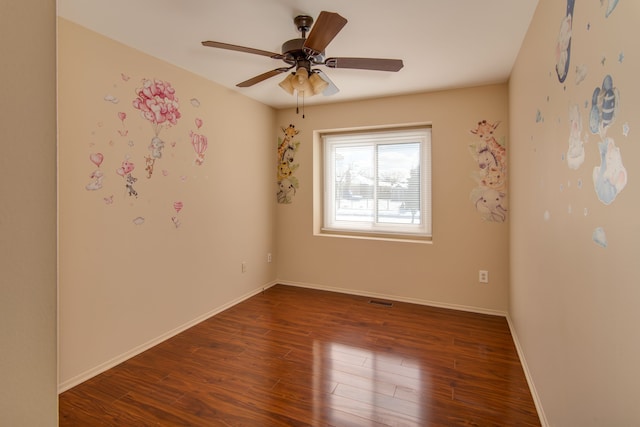 unfurnished room featuring visible vents, dark wood finished floors, baseboards, and ceiling fan