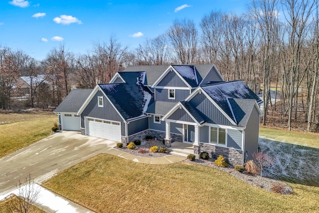 craftsman-style house featuring a garage, covered porch, and a front yard