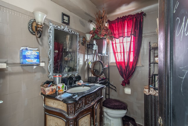 bathroom featuring tile walls, vanity, and toilet