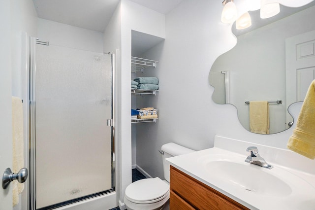 bathroom featuring an enclosed shower, vanity, and toilet