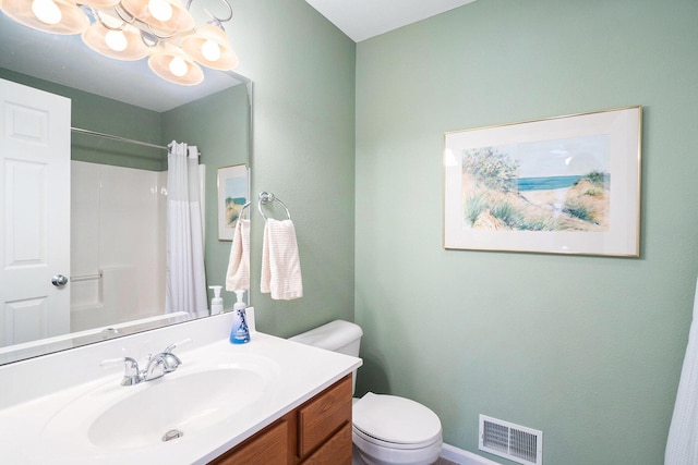 bathroom with vanity, curtained shower, toilet, and an inviting chandelier