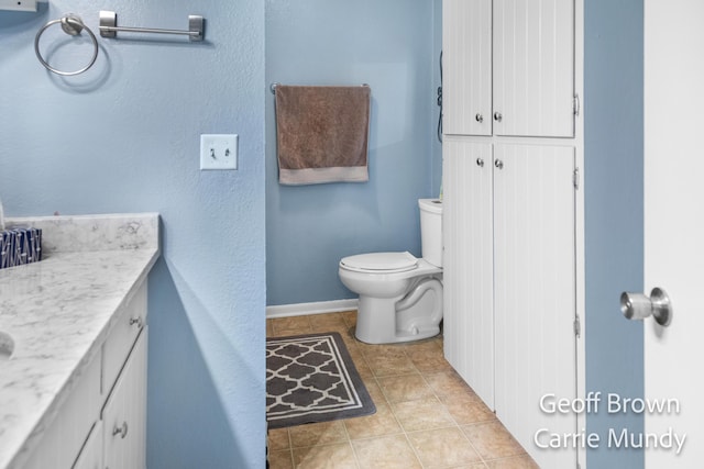 bathroom featuring tile patterned flooring, vanity, and toilet