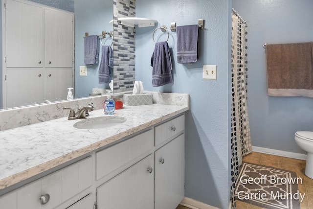 bathroom featuring vanity, toilet, and tile patterned flooring