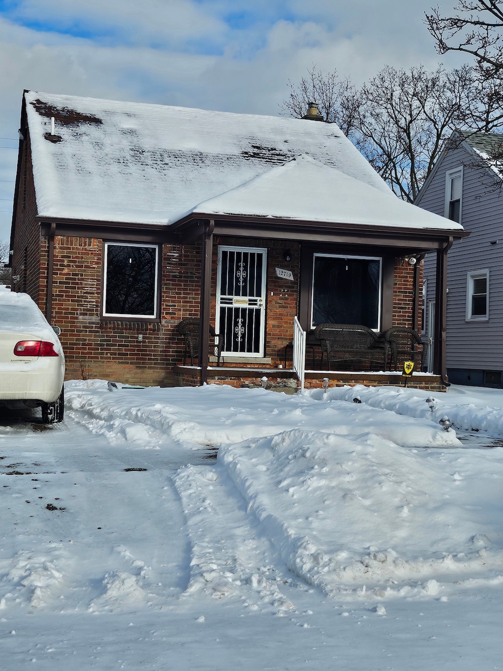 view of front of house with a porch and brick siding