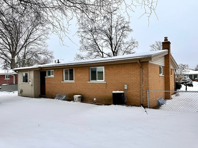 snow covered back of property with central AC unit