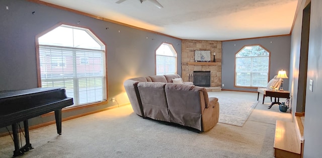 carpeted living room with crown molding, a fireplace, baseboards, and ceiling fan