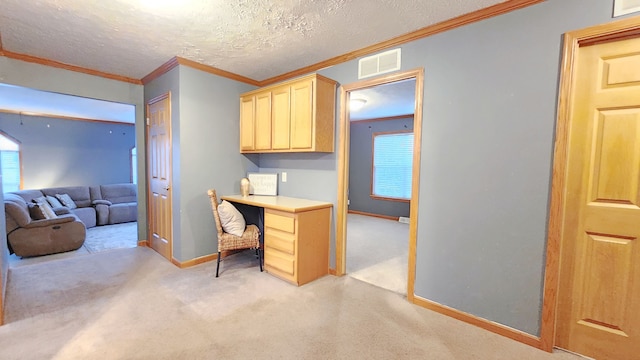 office area with a healthy amount of sunlight, visible vents, ornamental molding, a textured ceiling, and light colored carpet