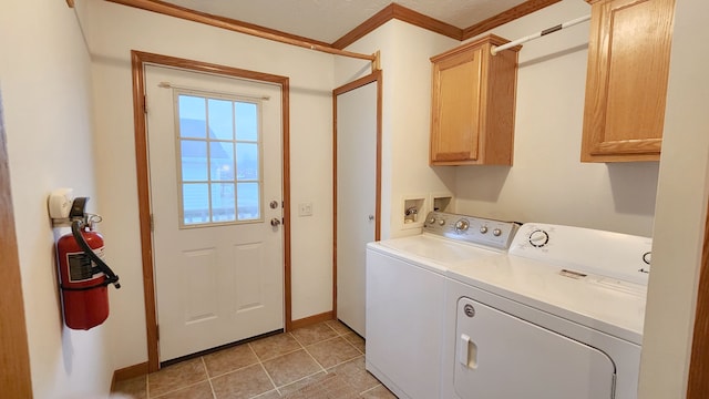 washroom with baseboards, ornamental molding, light tile patterned floors, washer and dryer, and cabinet space