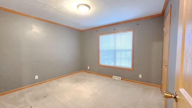 carpeted spare room featuring visible vents, a textured ceiling, baseboards, and ornamental molding