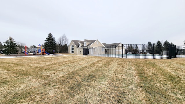 view of yard with playground community, a pool, and fence