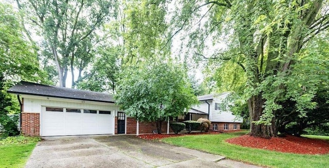 tri-level home with an attached garage, concrete driveway, and brick siding