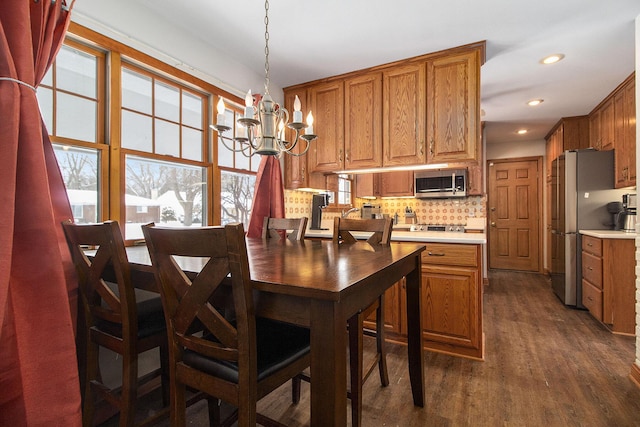 dining room featuring dark wood-style floors, recessed lighting, and a notable chandelier