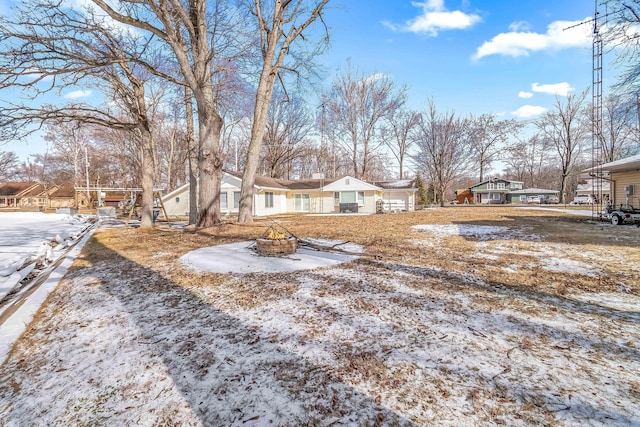 yard covered in snow with an outdoor fire pit