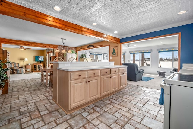 kitchen with light brown cabinetry, a center island, pendant lighting, ceiling fan, and white range oven