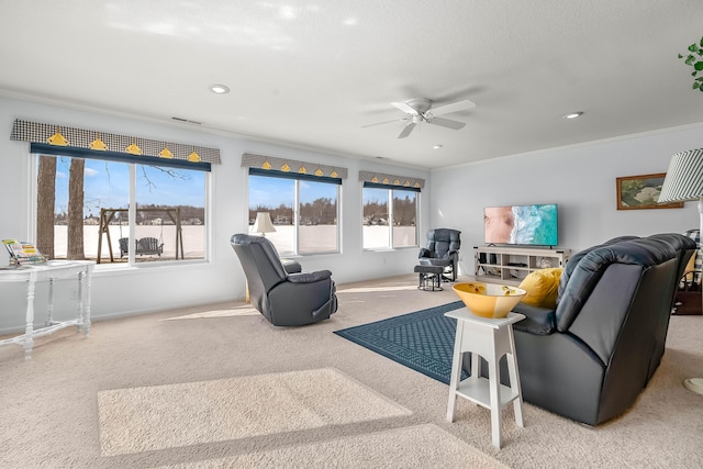 carpeted living room featuring ornamental molding and ceiling fan