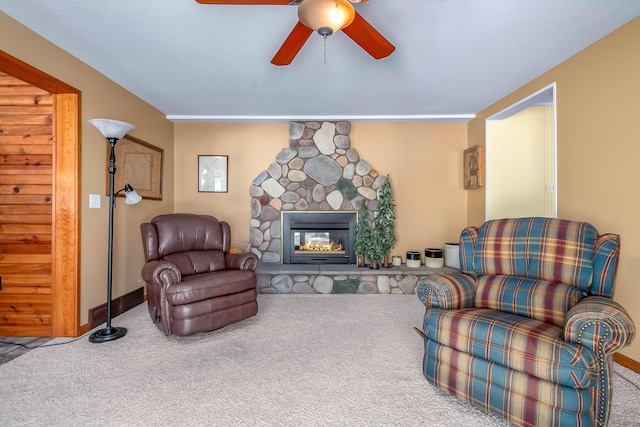 carpeted living room featuring ceiling fan and a fireplace