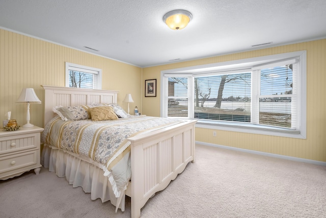 bedroom with crown molding, light carpet, multiple windows, and a textured ceiling