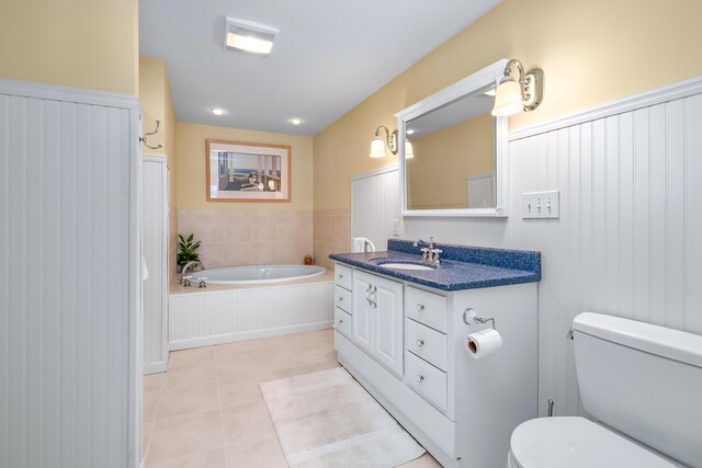 bathroom featuring vanity, a tub to relax in, tile patterned floors, and toilet