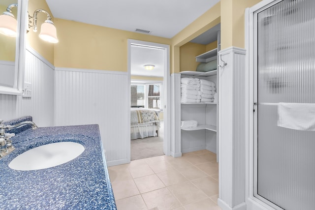 bathroom featuring walk in shower, vanity, and tile patterned flooring