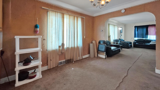 interior space featuring a healthy amount of sunlight, carpet, and a notable chandelier