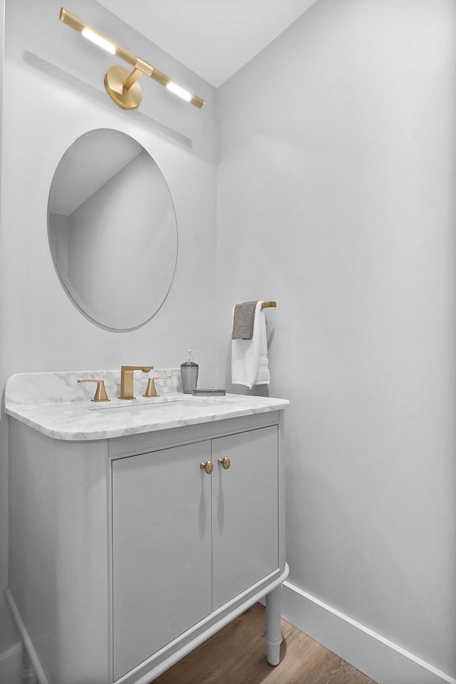 bathroom featuring wood finished floors, vanity, and baseboards