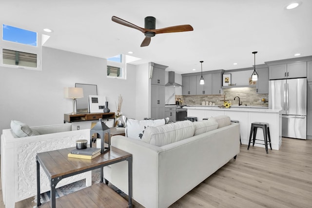 living room with ceiling fan, recessed lighting, and light wood-style floors