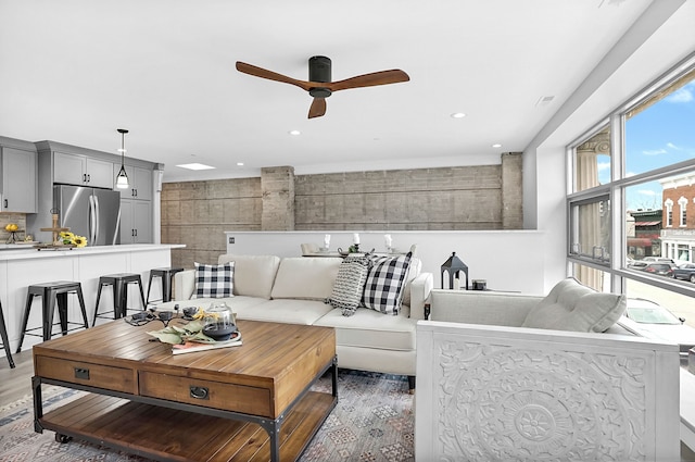 living area featuring recessed lighting, light wood-style flooring, and a ceiling fan