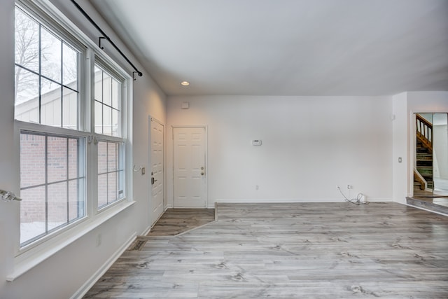 spare room with plenty of natural light and light hardwood / wood-style flooring