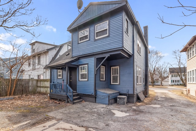 view of front of house with fence and central AC