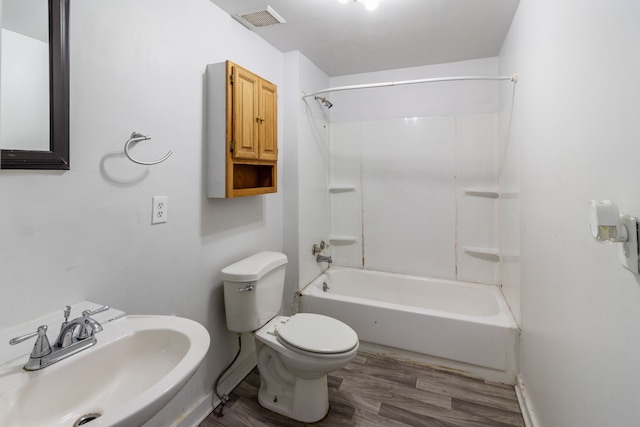 full bath with visible vents, toilet, a sink, shower / tub combination, and wood finished floors