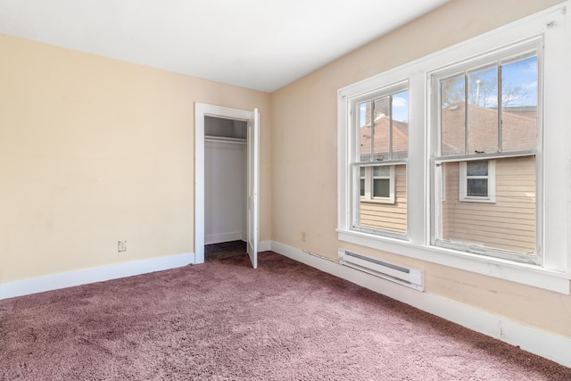 unfurnished bedroom featuring a baseboard radiator, baseboards, a closet, and carpet flooring