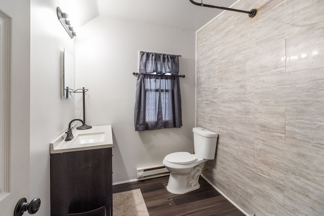 bathroom featuring vanity, wood finished floors, lofted ceiling, toilet, and baseboard heating