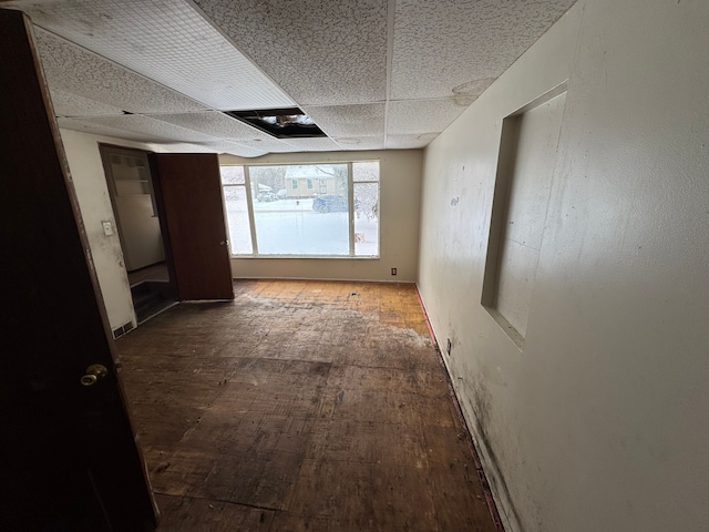 hall featuring a drop ceiling and wood finished floors