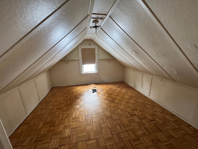 additional living space featuring a ceiling fan, lofted ceiling, and a textured ceiling