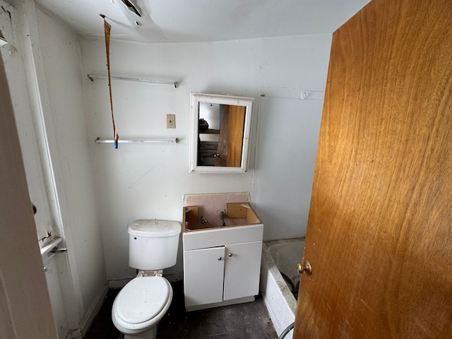 bathroom with a bathtub, vanity, and toilet