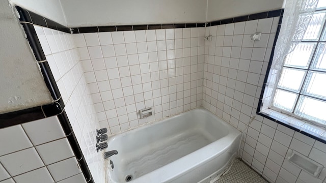 bathroom featuring tile walls, a tub, and tile patterned floors