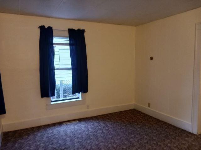 carpeted empty room with baseboards