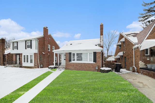 view of front of property with brick siding, a chimney, and a front yard